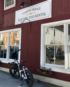 An electric bike is parked in front of covered bridge electric bike rental