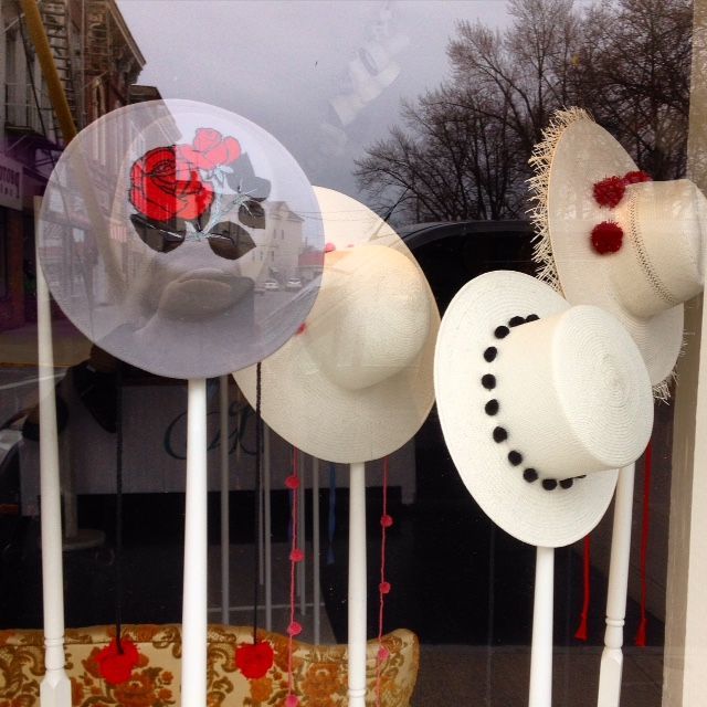 A bunch of hats are displayed in a window
