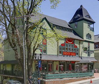 A green building with a sign that says infinity hall