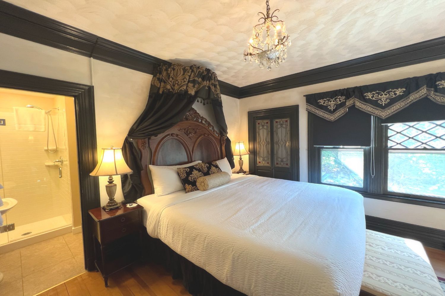 A romantic bedroom at a New England Country Inn with an antique wood bed and a vintage chandelier.