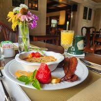 A table topped with plates of food and a vase of flowers.
