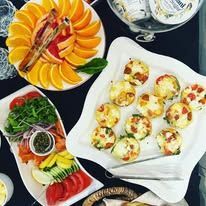 A breakfast display with smoked salmon, petite egg bites, and fresh fruit on a table