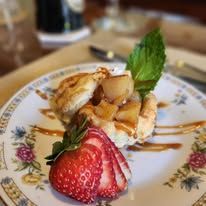 A close-up of a plate of food with strawberries on a table with vintage china.
