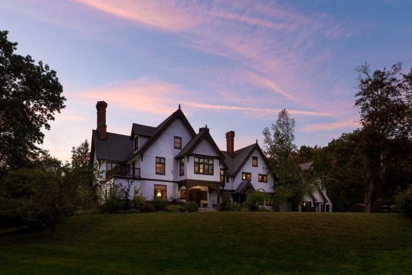 A large white house with a pink sky in the background