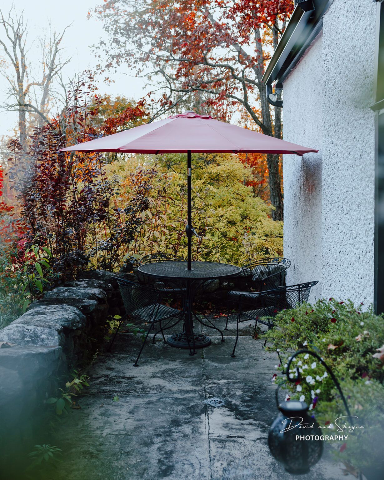 A table and chairs under an umbrella on a patio.