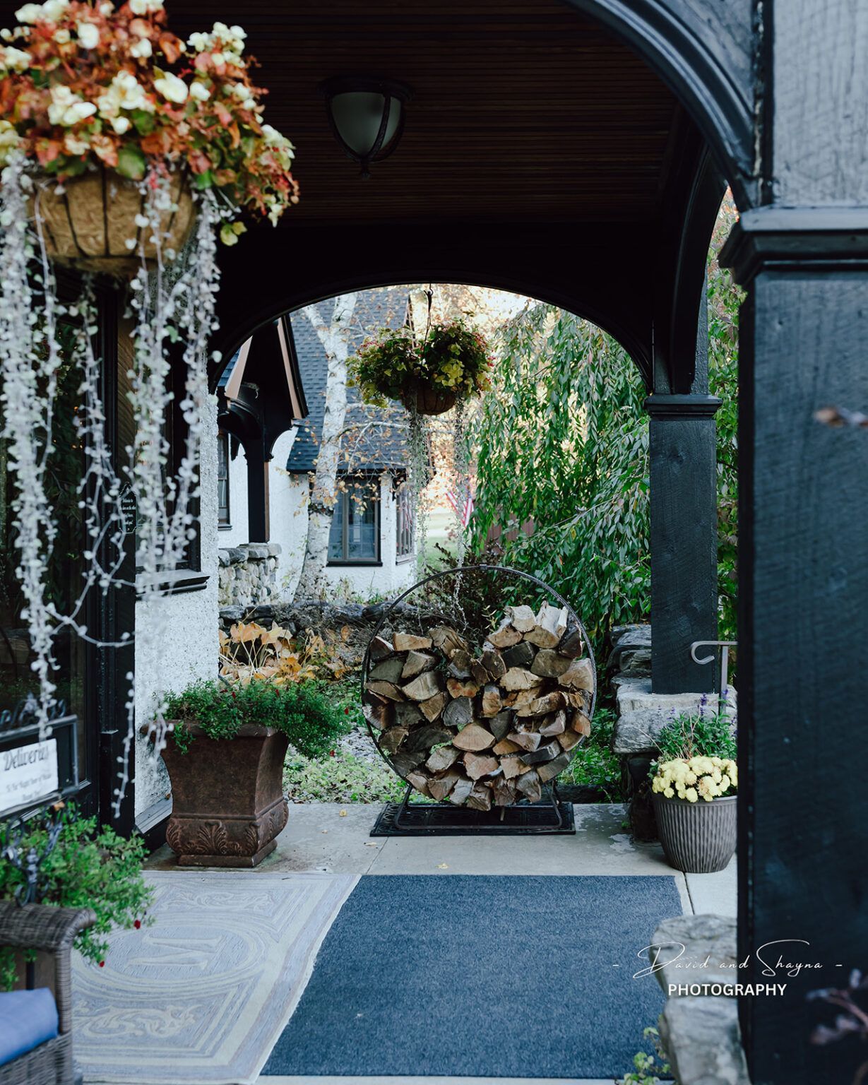 A porch with flowers and a pile of logs