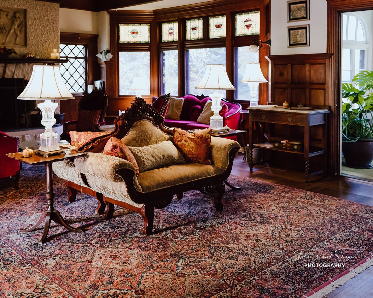 A Victorian living room with a couch and lamps and a rug