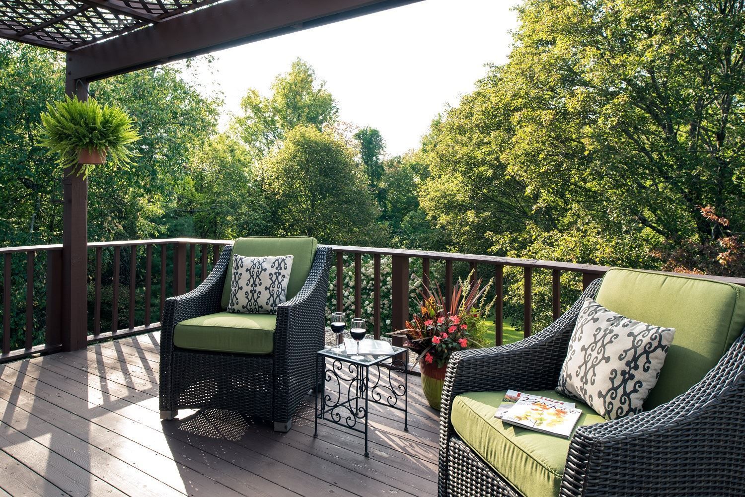 Two chairs and a table on a deck with trees in the background at a New England Country Inn
