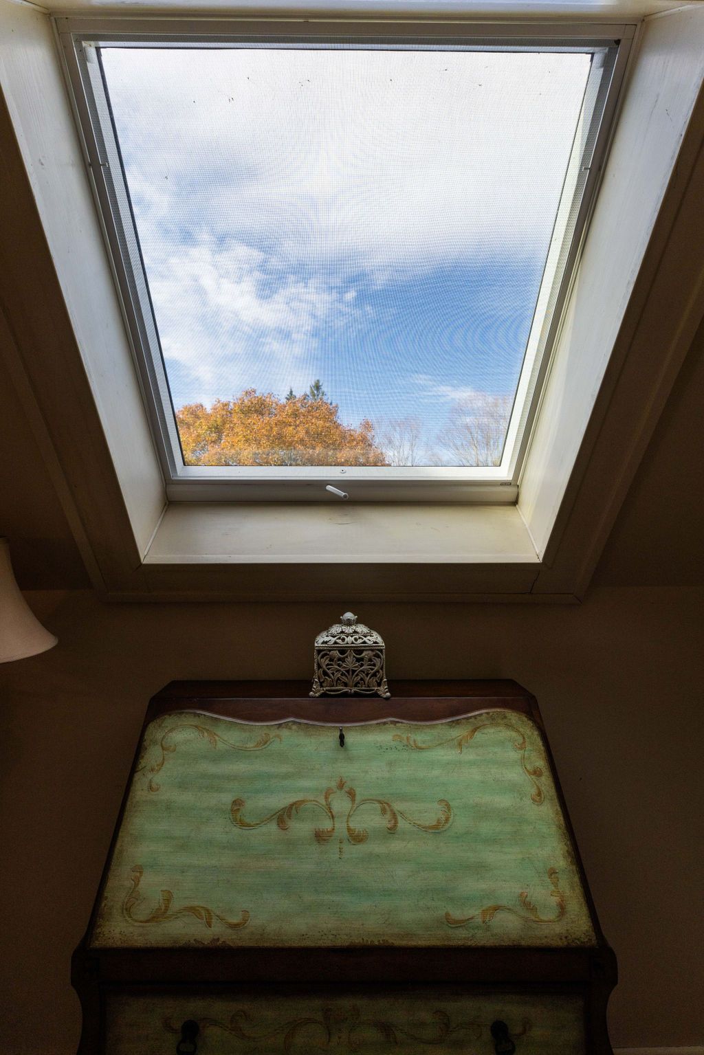 A skylight in a room with a desk in front of it.
