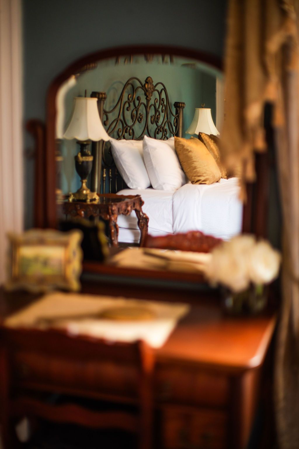 A bedroom with a large bed and a desk in front of it