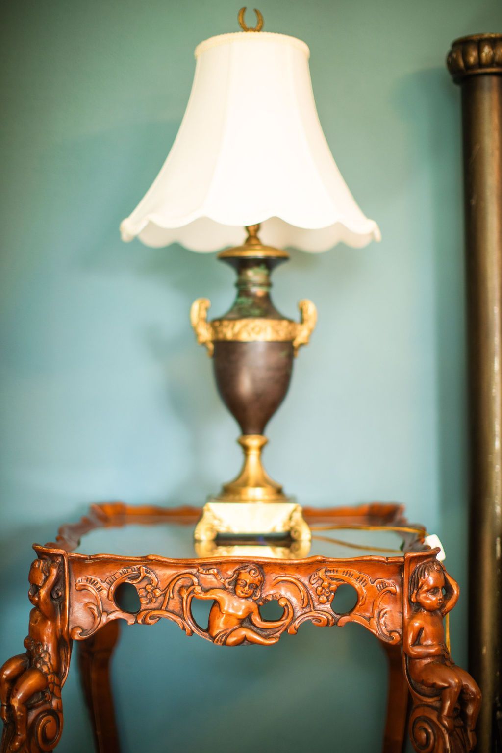 A lamp with a white shade is sitting on a wooden table