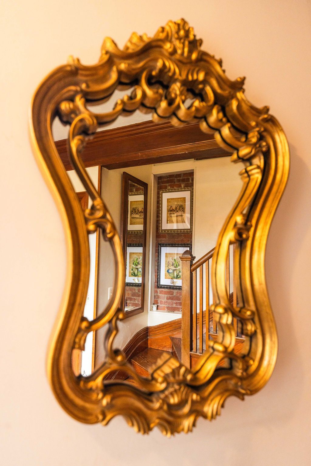 A gold mirror with a staircase reflection in it