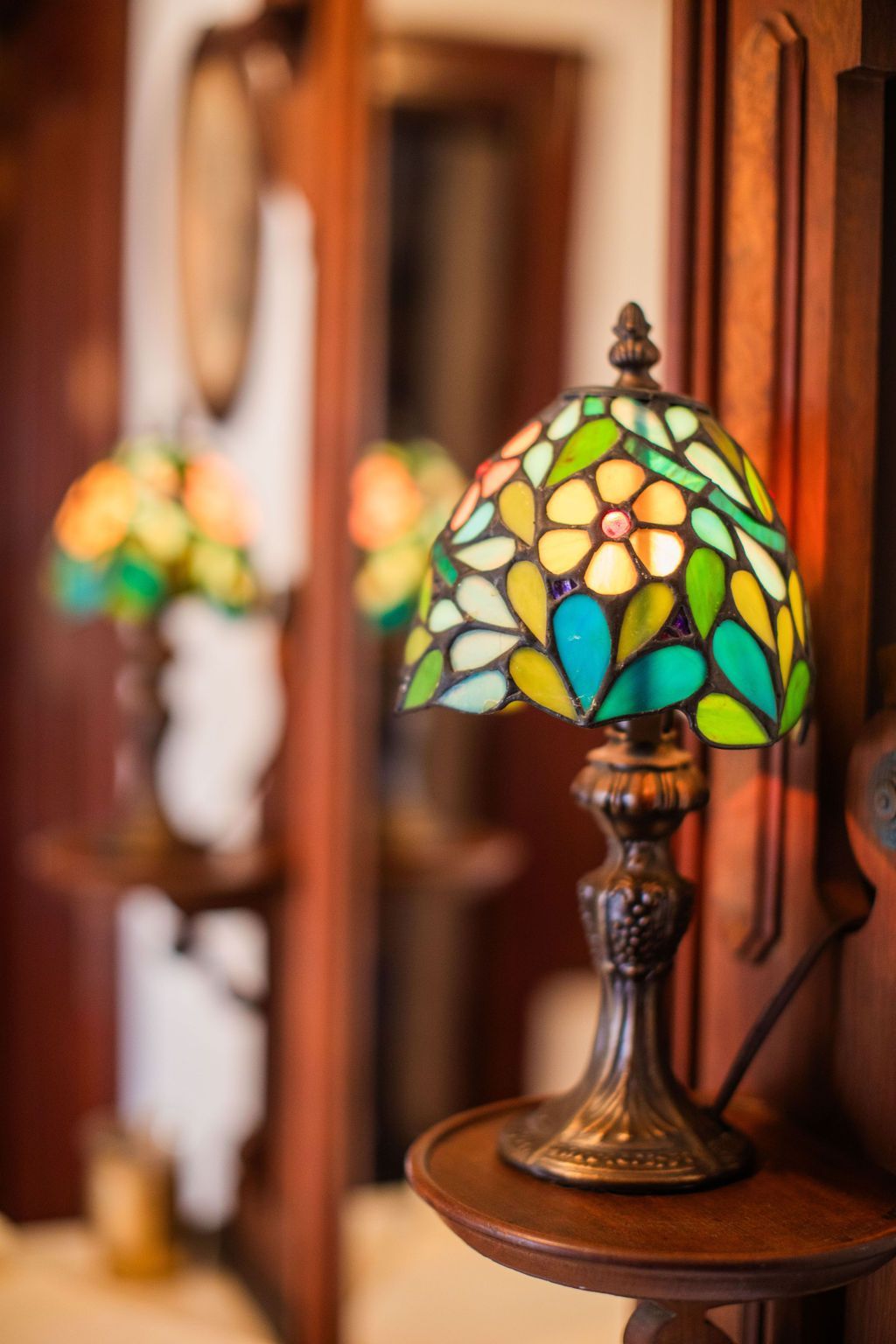 A stained glass lamp is sitting on a wooden table