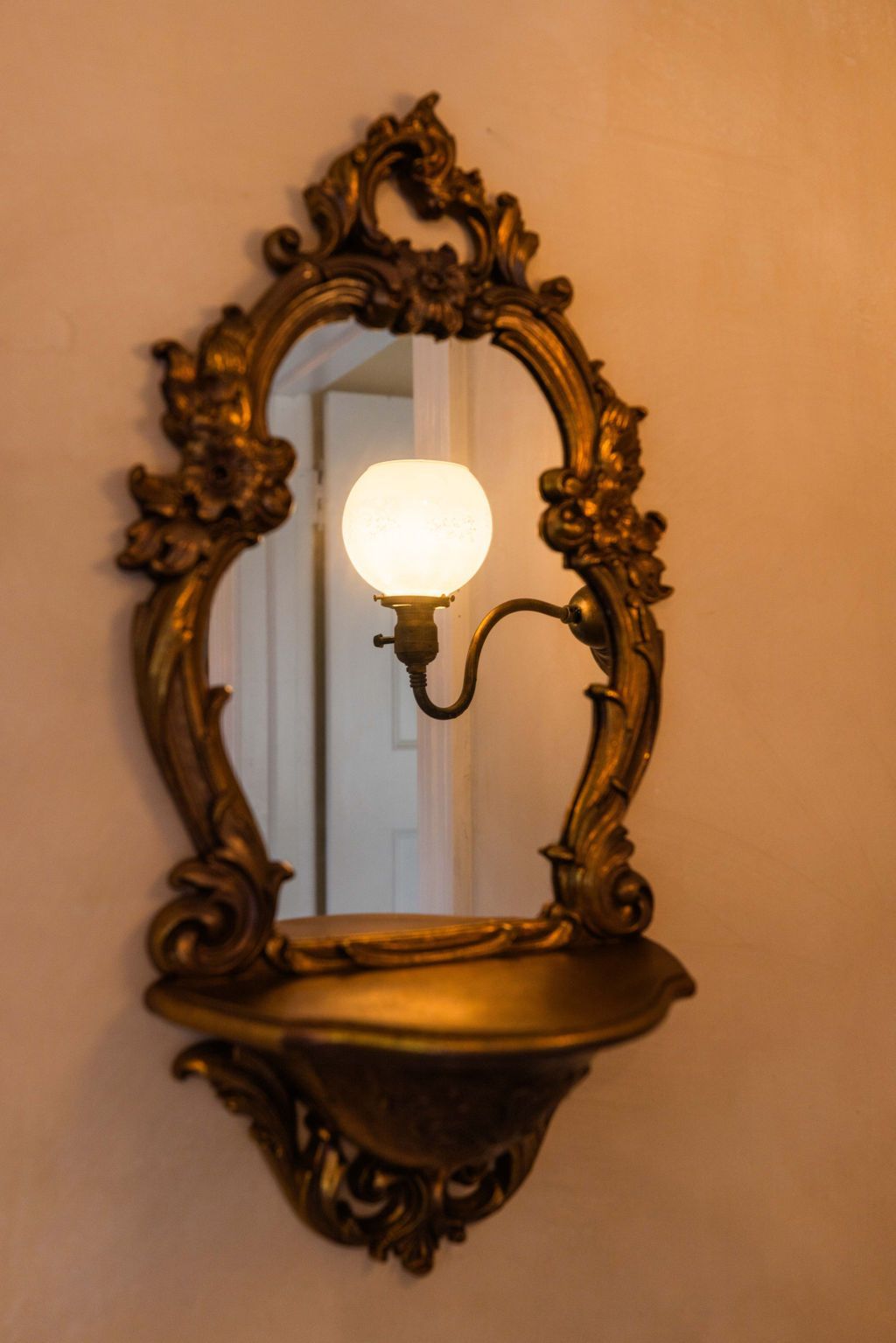 A mirror with a light behind it on a wall