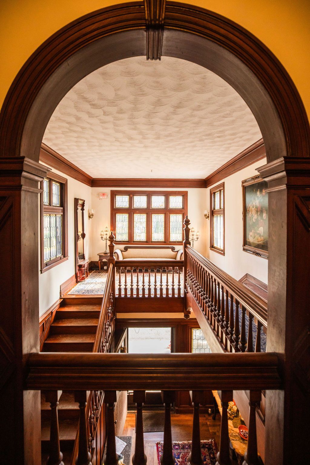 A view of a staircase from a balcony in a house.