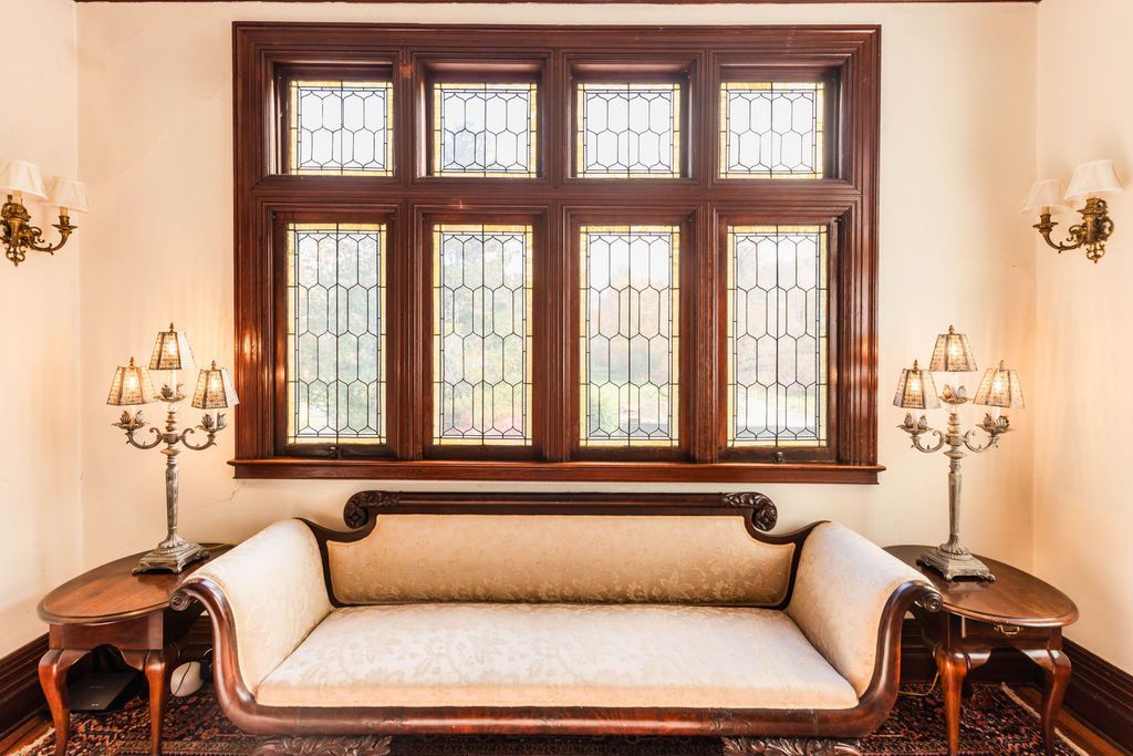A living room with a couch and stained glass windows.