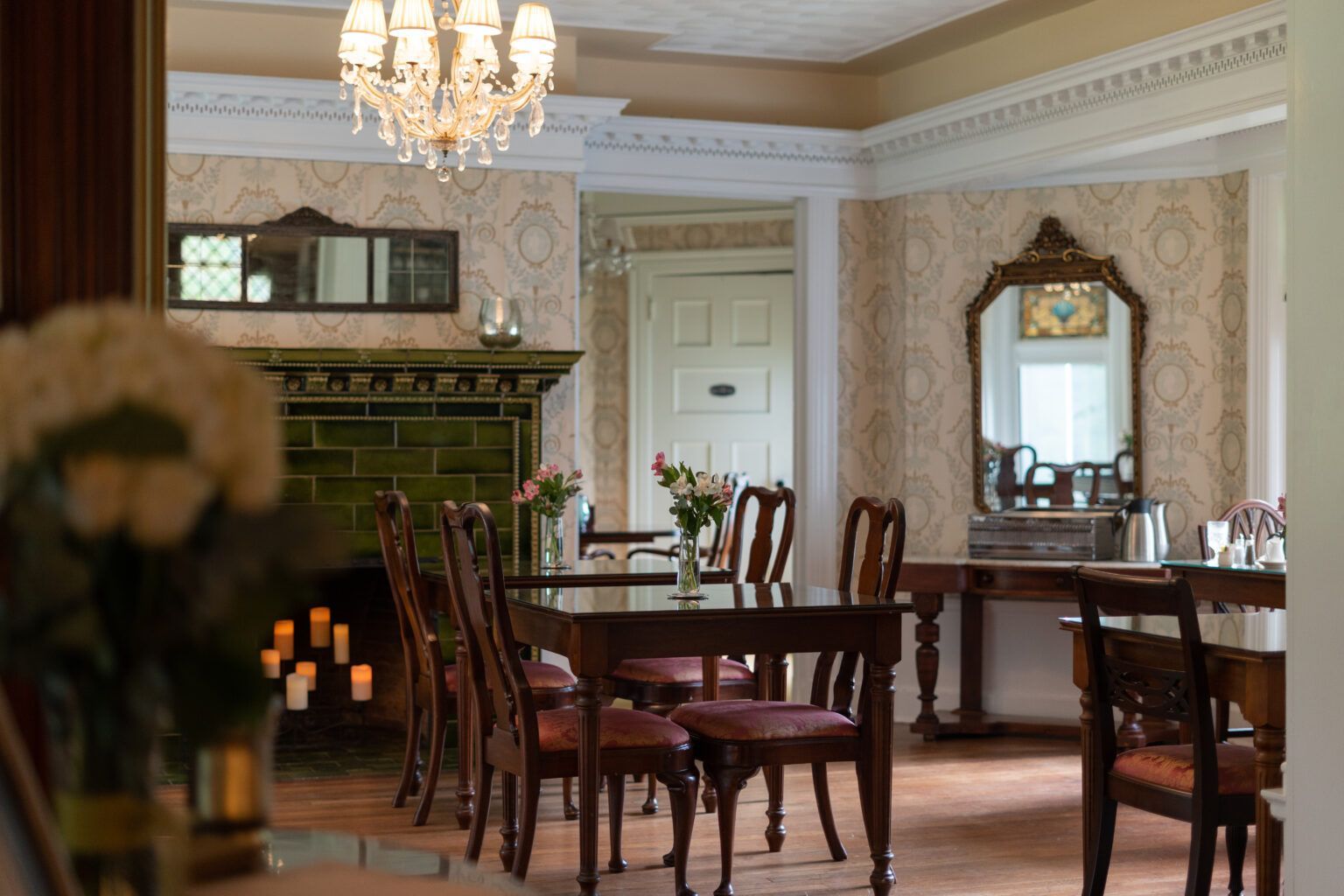 A Victorian restaurant dining room with a table and chairs and a fireplace.