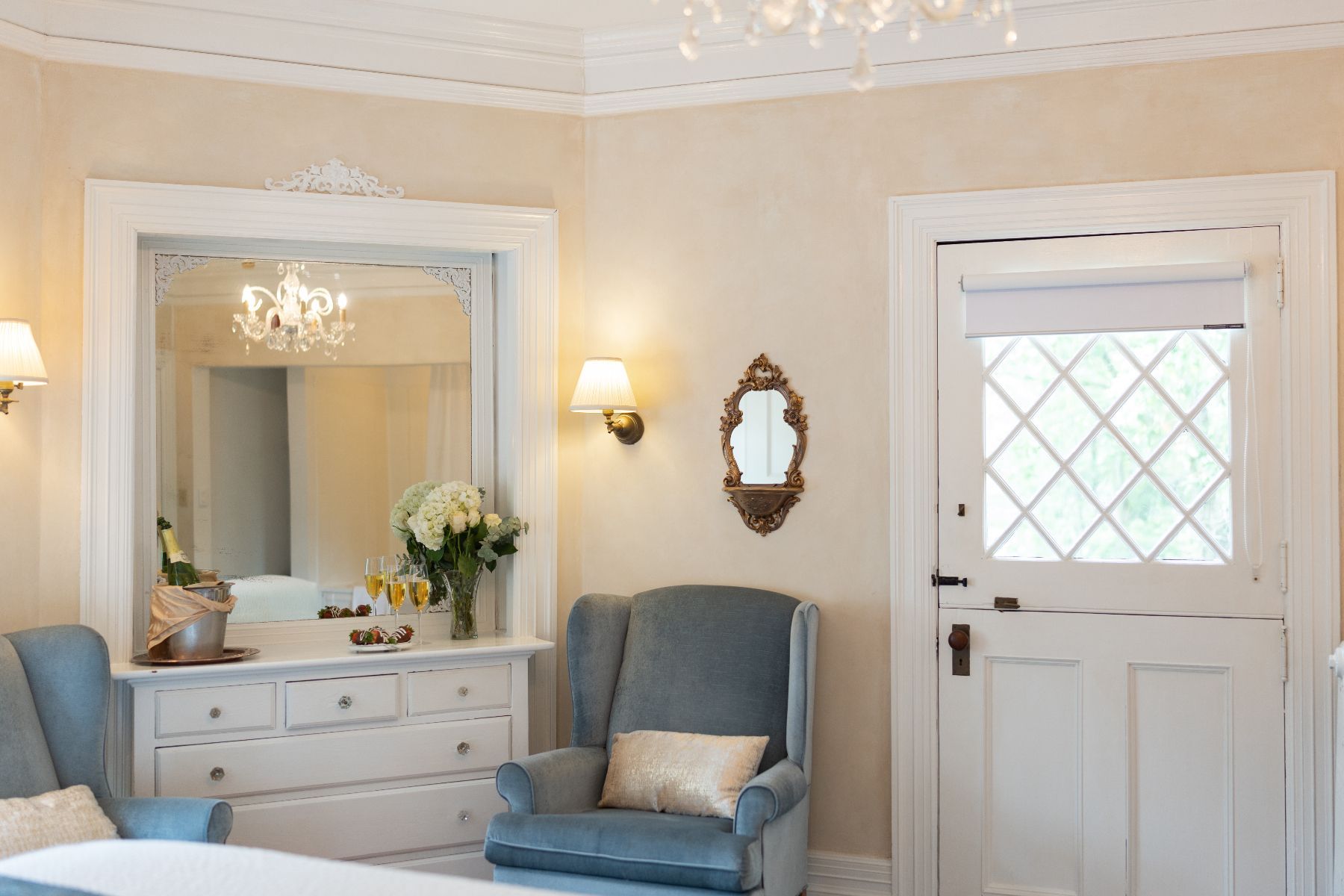 A Victorian bedroom with a bed, chair, dresser ,and mirror.