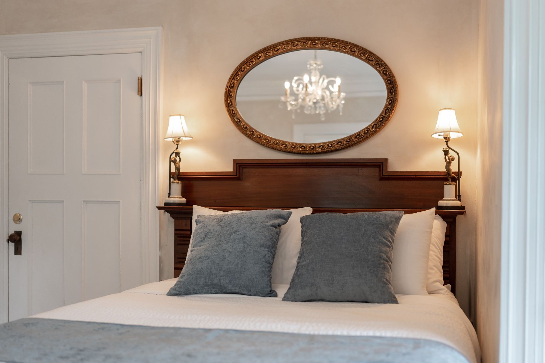 A Victorian bedroom at a New England Country Inn with a bed and a mirror on the wall