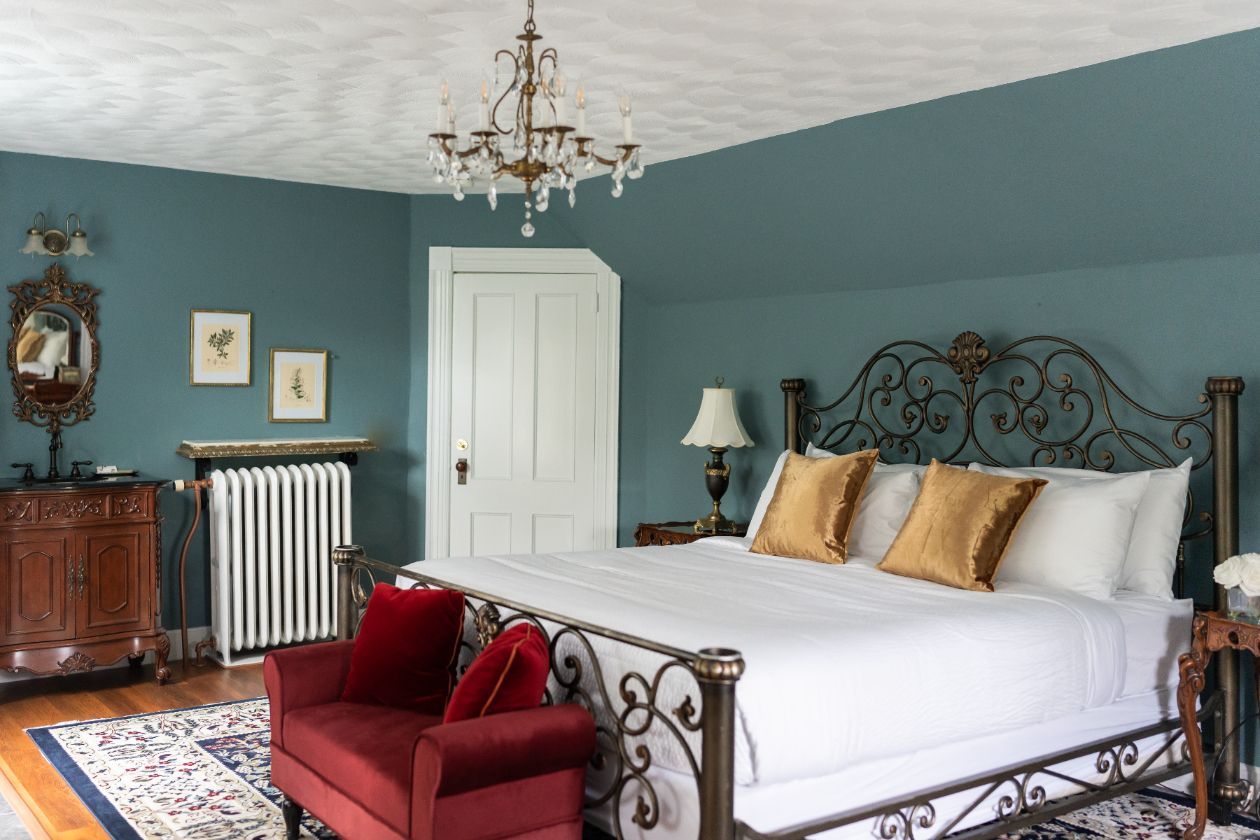 A bedroom at a New England Country Inn with a king-size bed and a red bench
