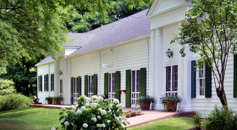 A large white house with green shutters on the windows