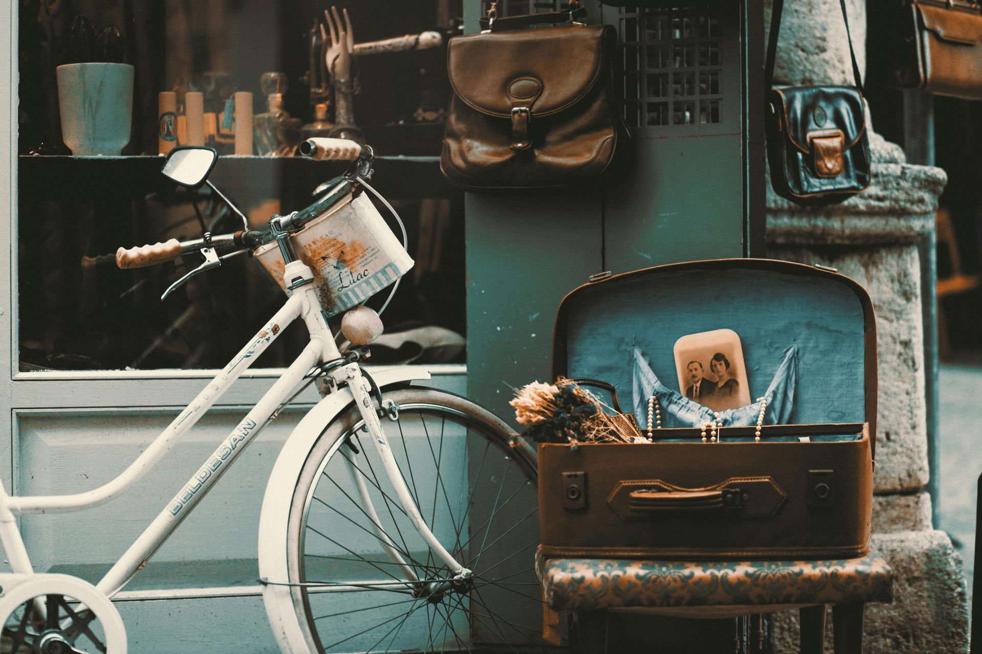 A white bicycle is parked in front of a store.