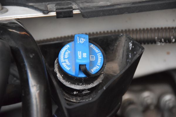 A close up of a blue oil cap on a car engine.