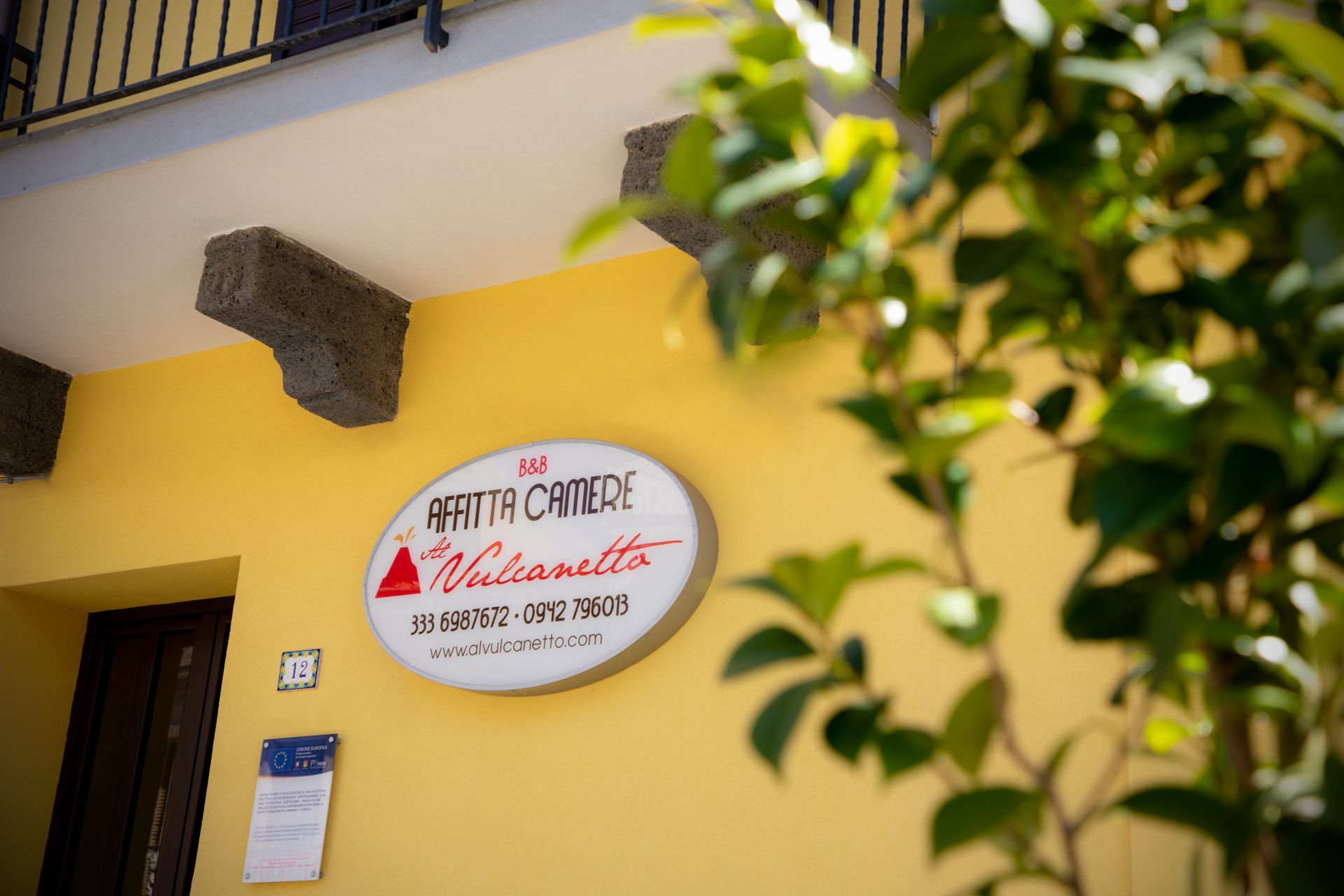Un edificio giallo con un cartello che dice 'agriturismo vulcanico'