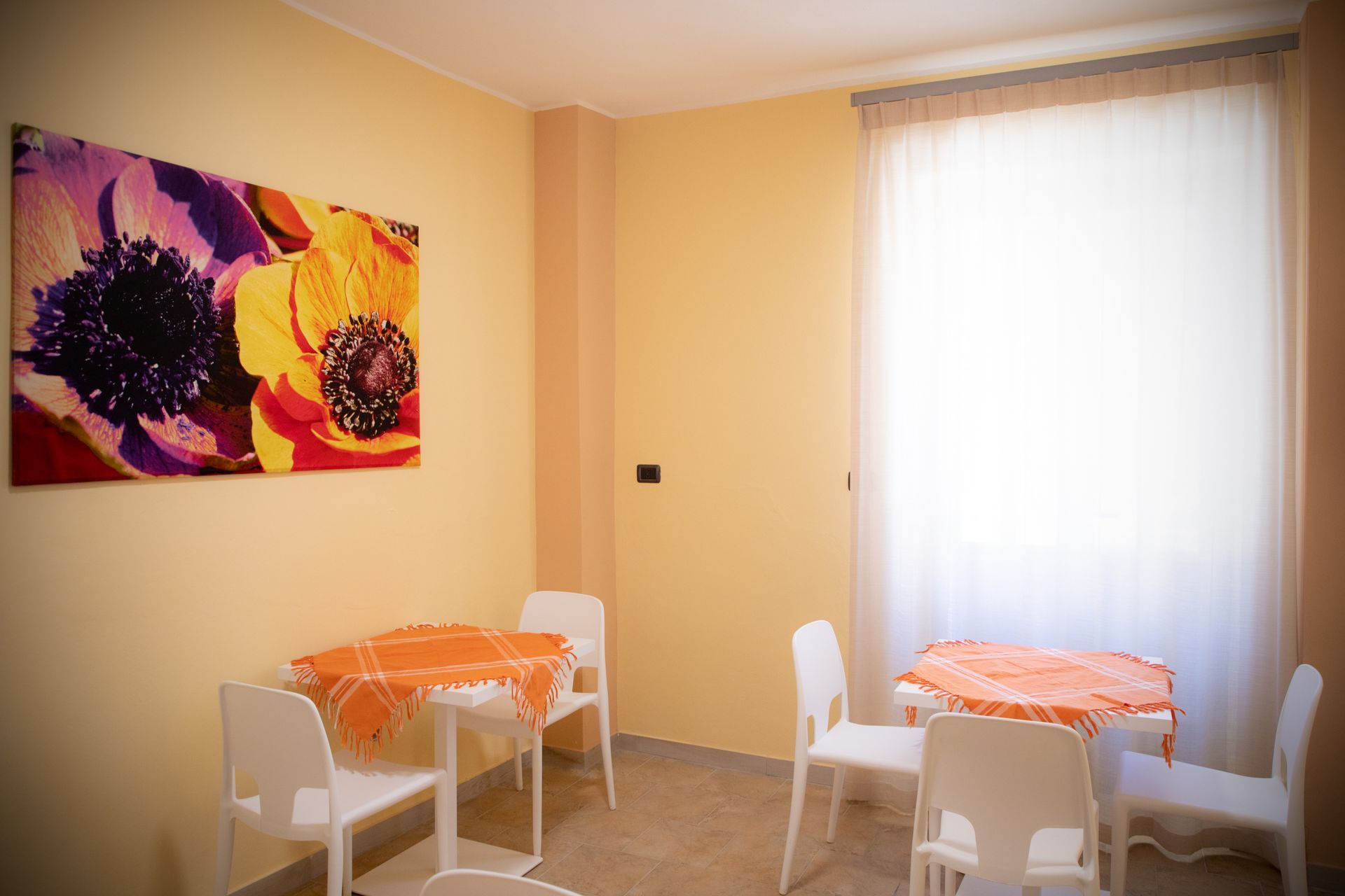 Una stanza con un tavolo e delle sedie e un dipinto sul muro