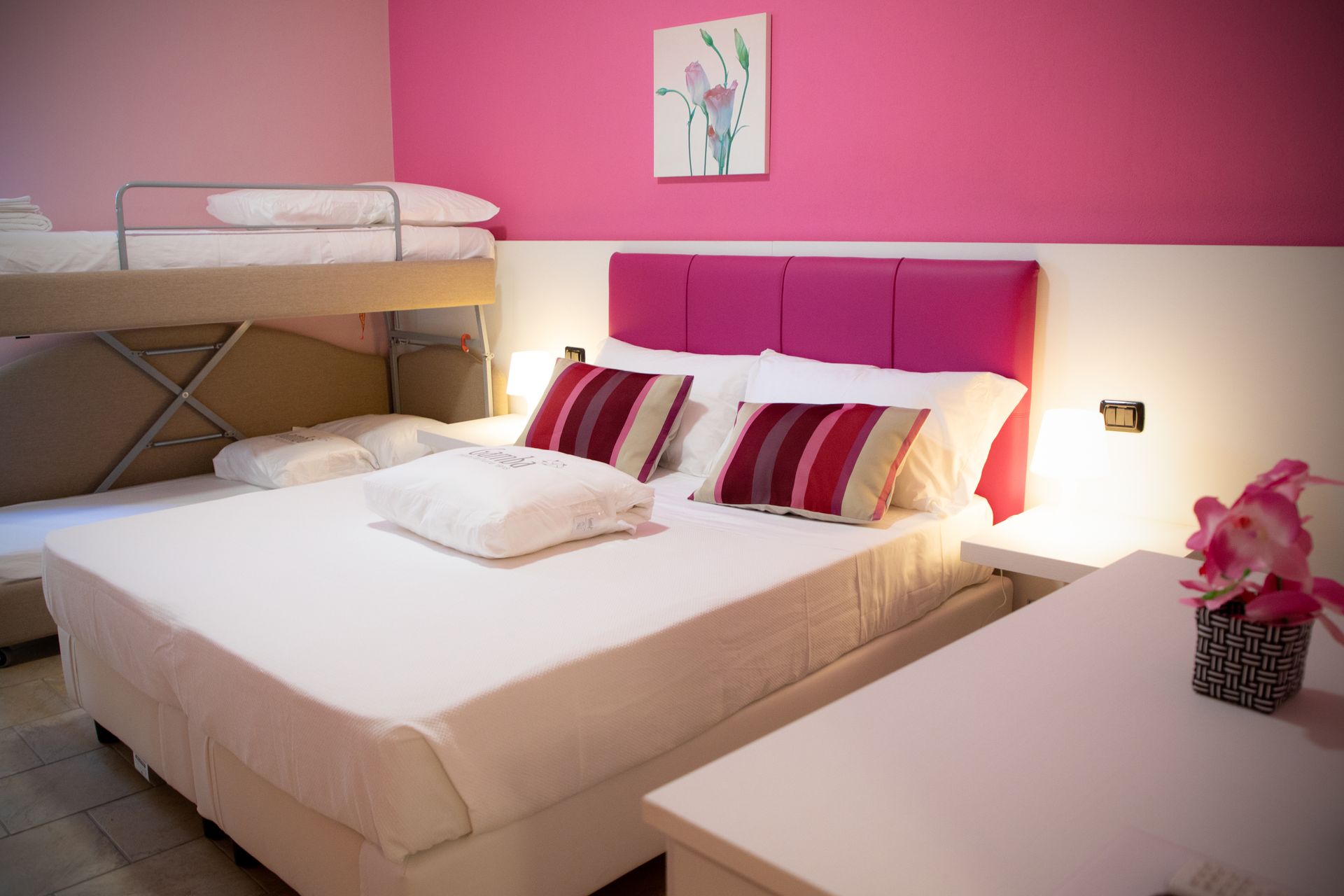 Una camera con un letto grande e due letti a castello