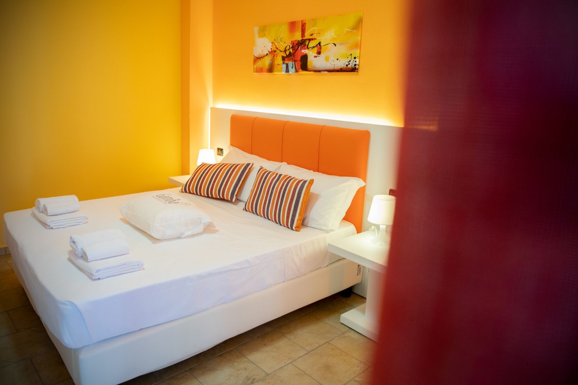 Una stanza d'albergo con un letto grande e un quadro sul muro.