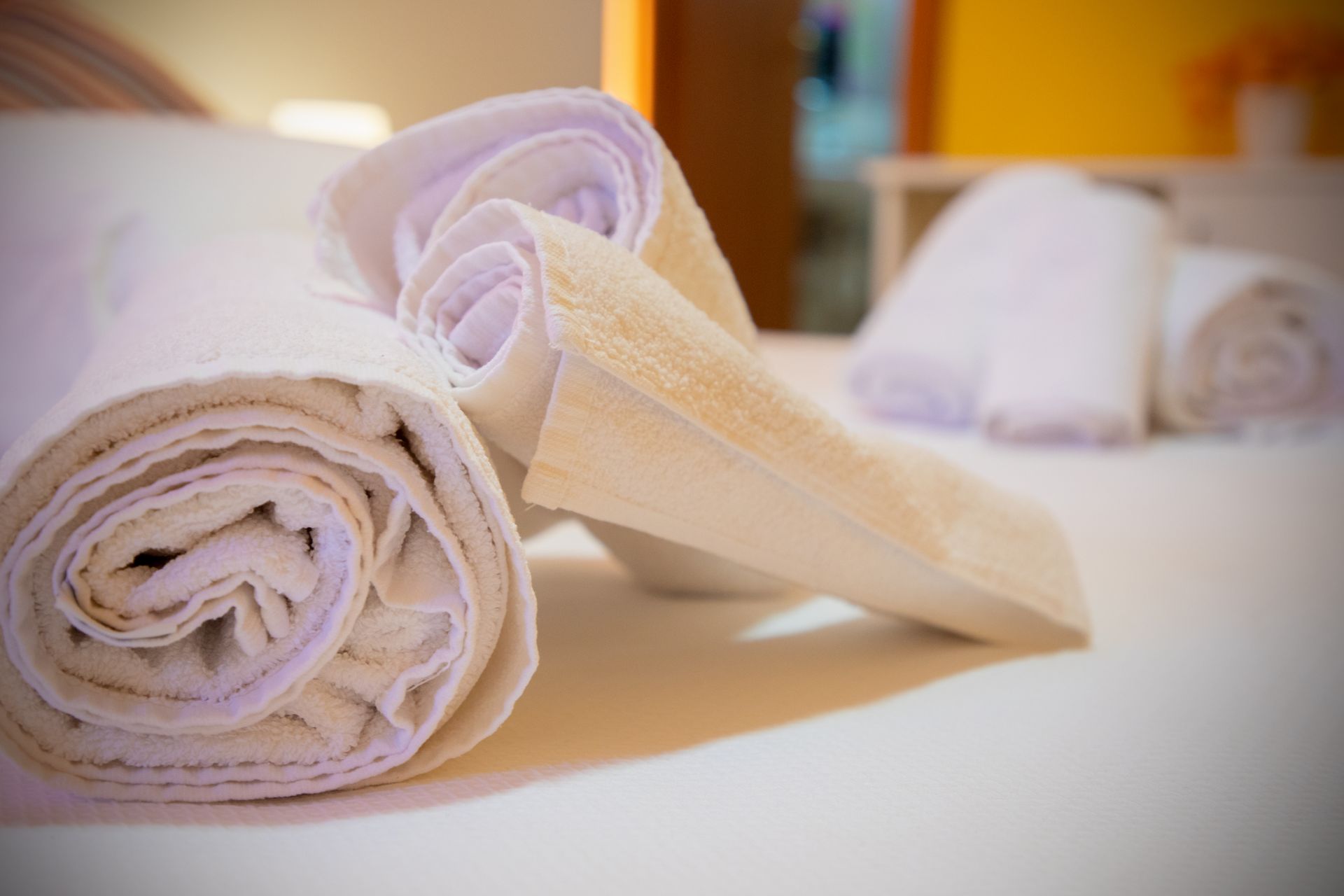 Un mucchio di asciugamani sono arrotolati su un letto