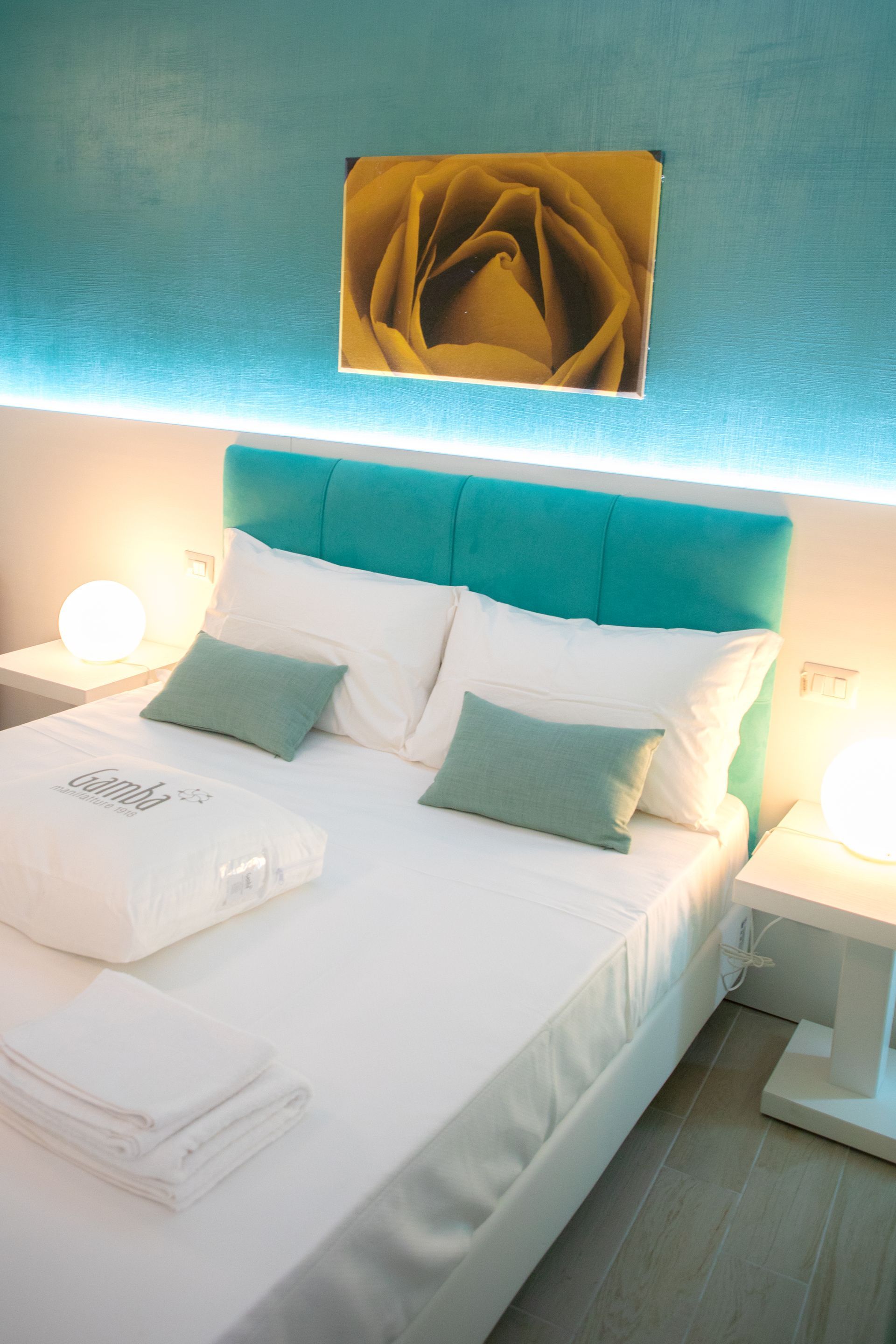 Una camera da letto con un letto e un quadro di una rosa sul muro