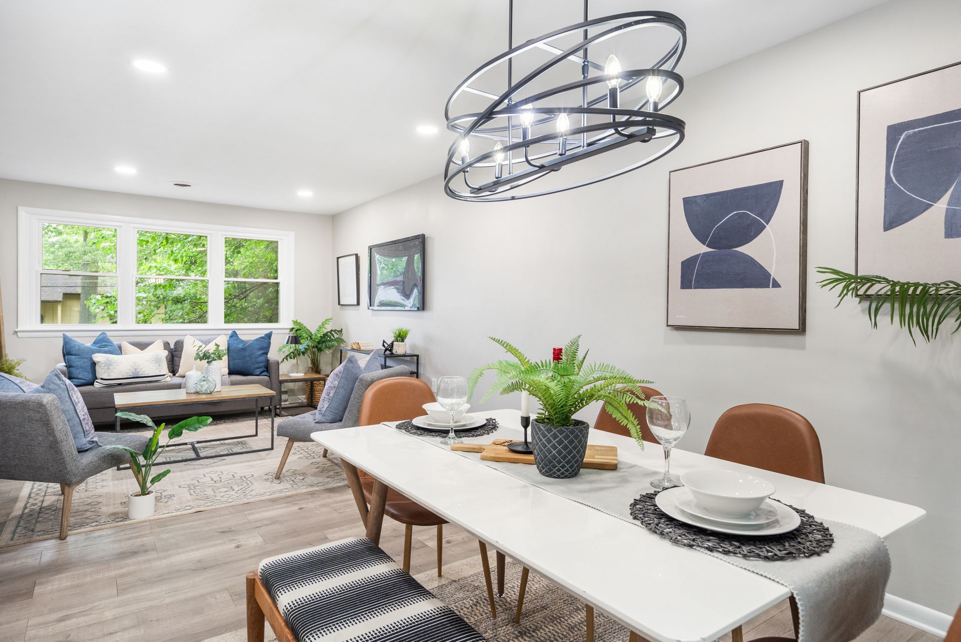 A dining room with a table and chairs and a chandelier hanging from the ceiling.