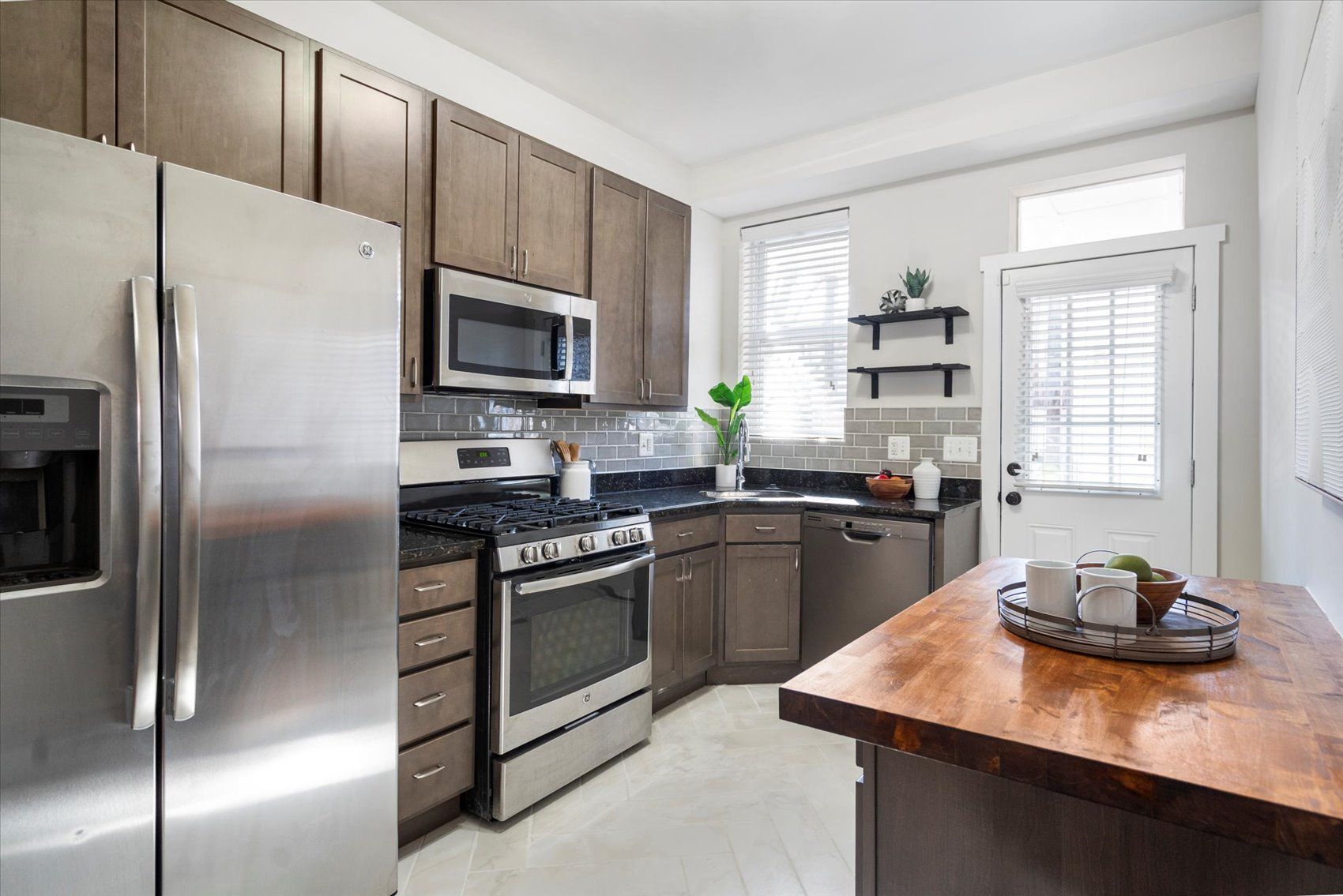 A kitchen with stainless steel appliances and wooden cabinets.