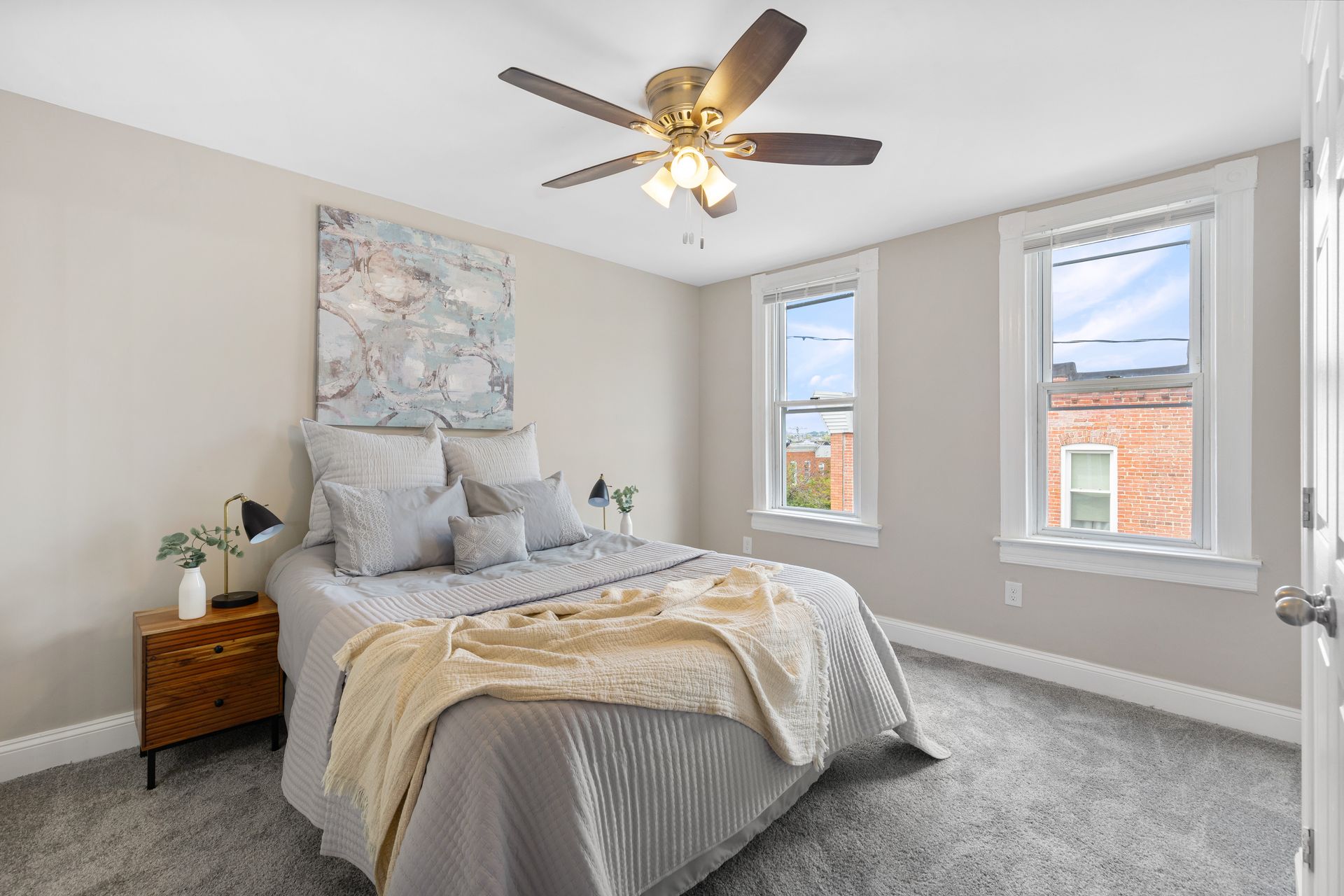 A bedroom with a bed , nightstand , and ceiling fan.
