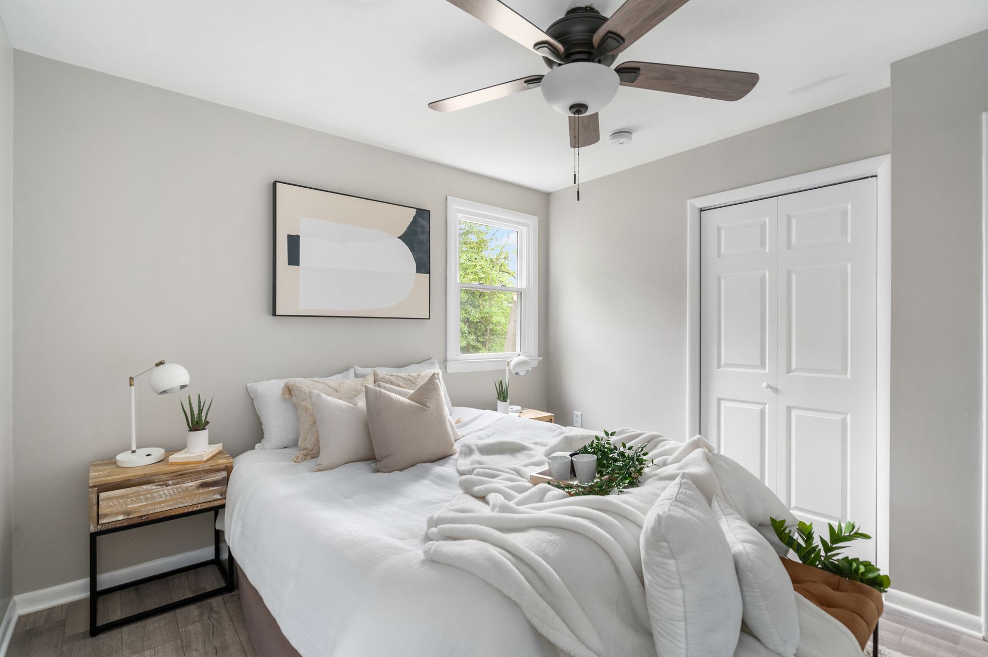 A bedroom with a bed , nightstand , and ceiling fan.