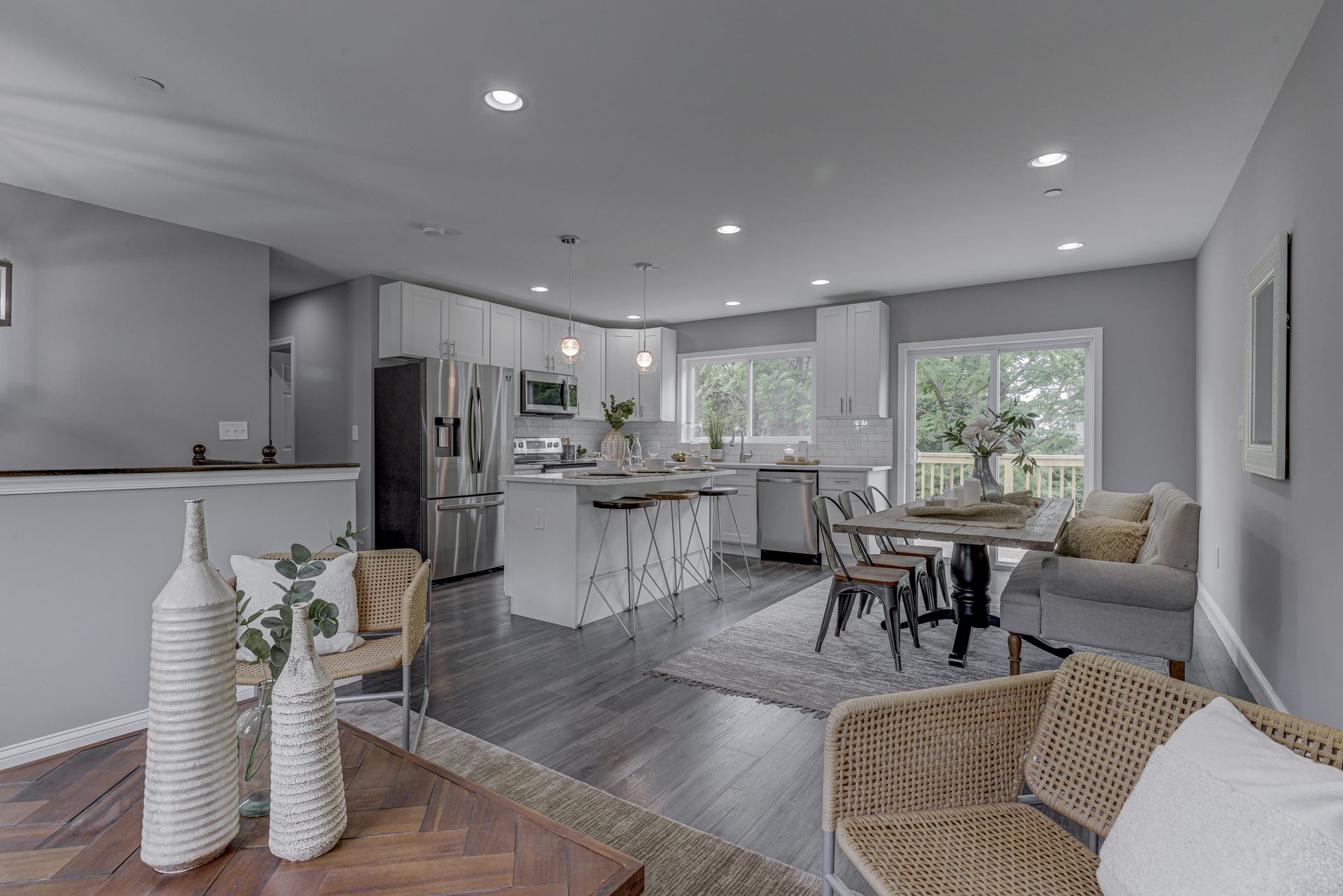 A living room filled with furniture and a kitchen with a table and chairs.