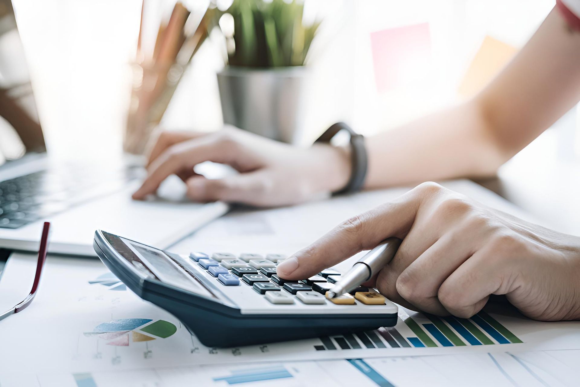 Person is Using a Calculator at a Desk — Darling Downs Bookkeeping Company in Gatton, QLD