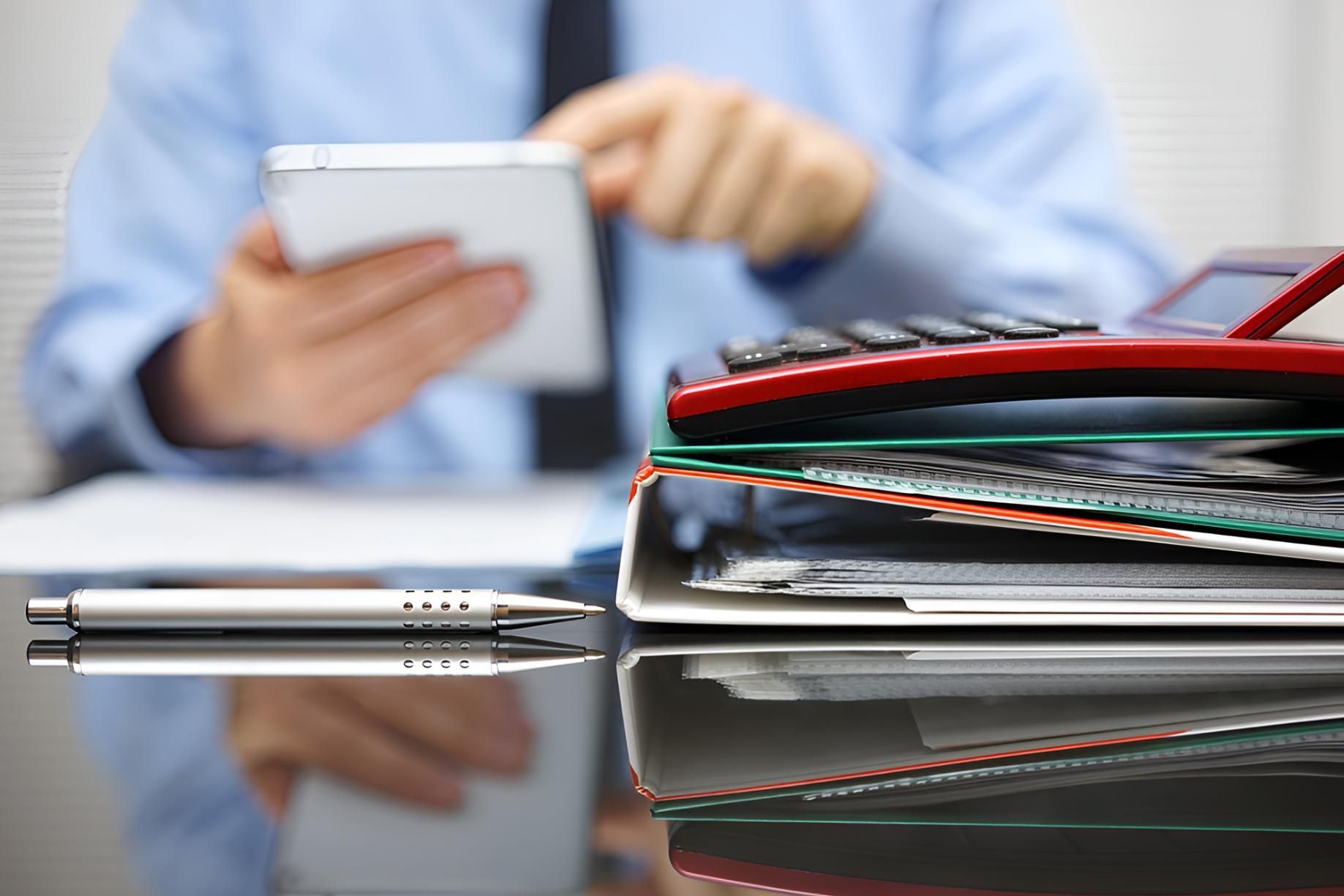 Man Sitting While Doing Bookkeeping on His Smartphone — Darling Downs Bookkeeping Company in Toowoomba City, QLD