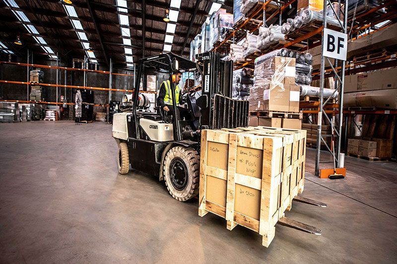 GO worker in warehouse with forklift