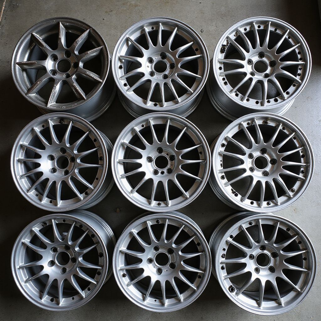 Nine silver alloy car wheels arranged in a grid.