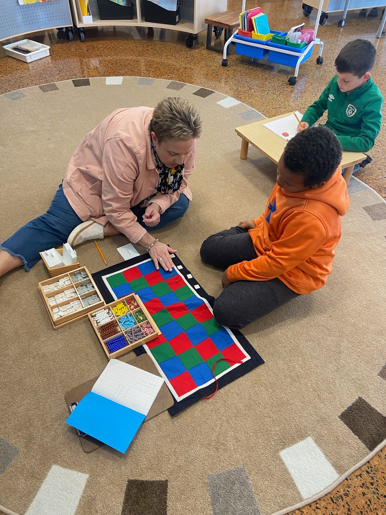 Montessori guide teachin maths to a montessori child with montessori math materials