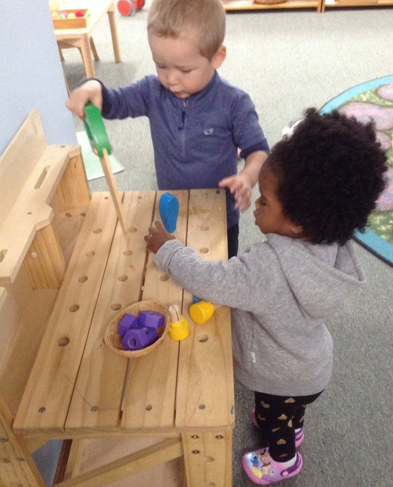 A boy and a girl are playing with wooden toys montessori style