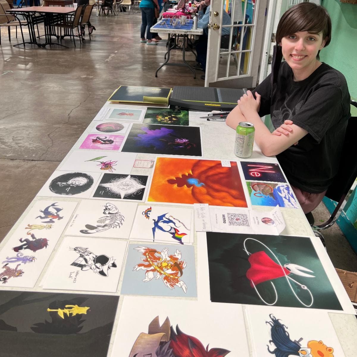 A woman is sitting at a table with many pictures on it