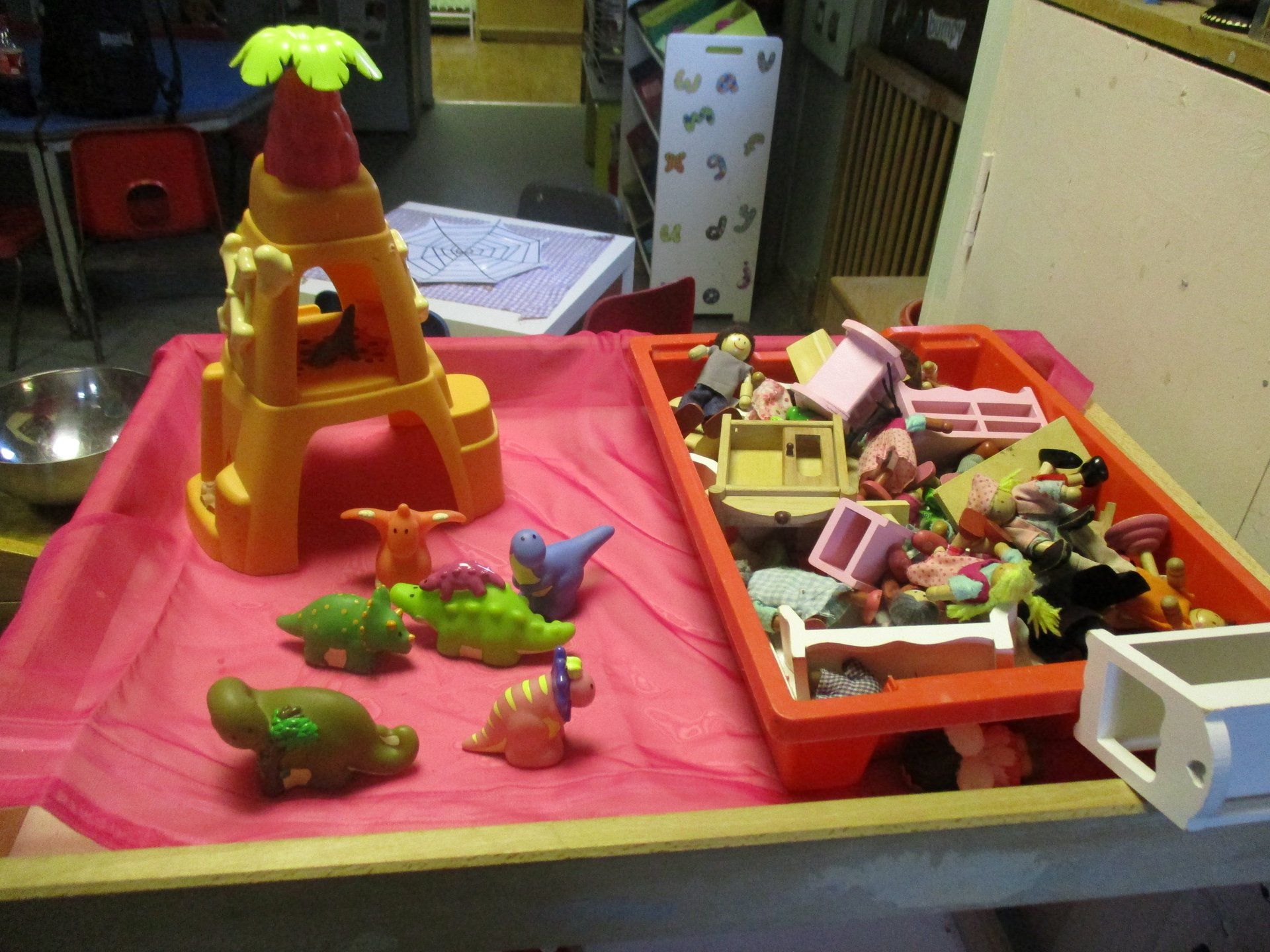 A table with a bunch of toy dinosaurs on it