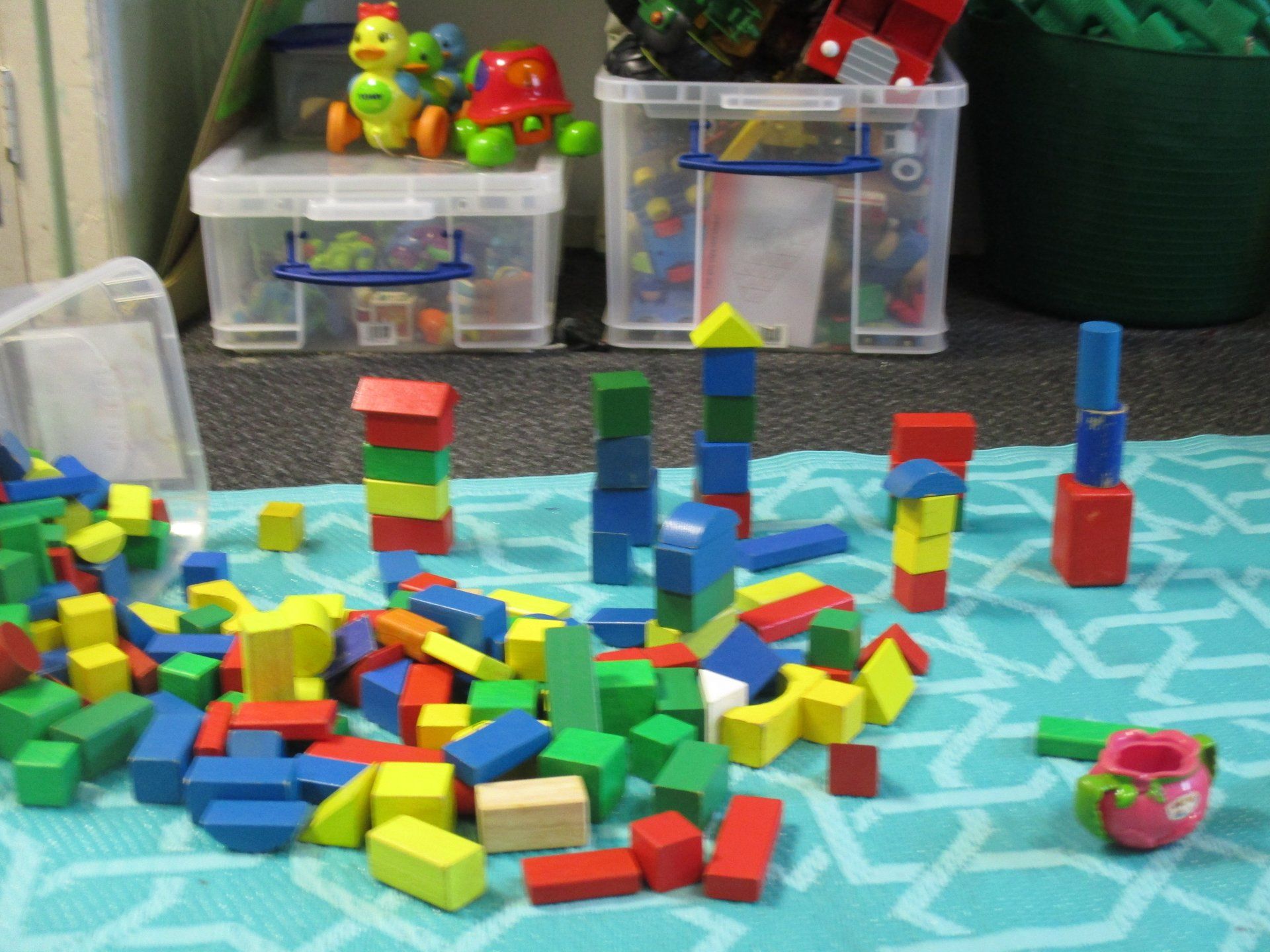A pile of colorful wooden blocks on a blue rug