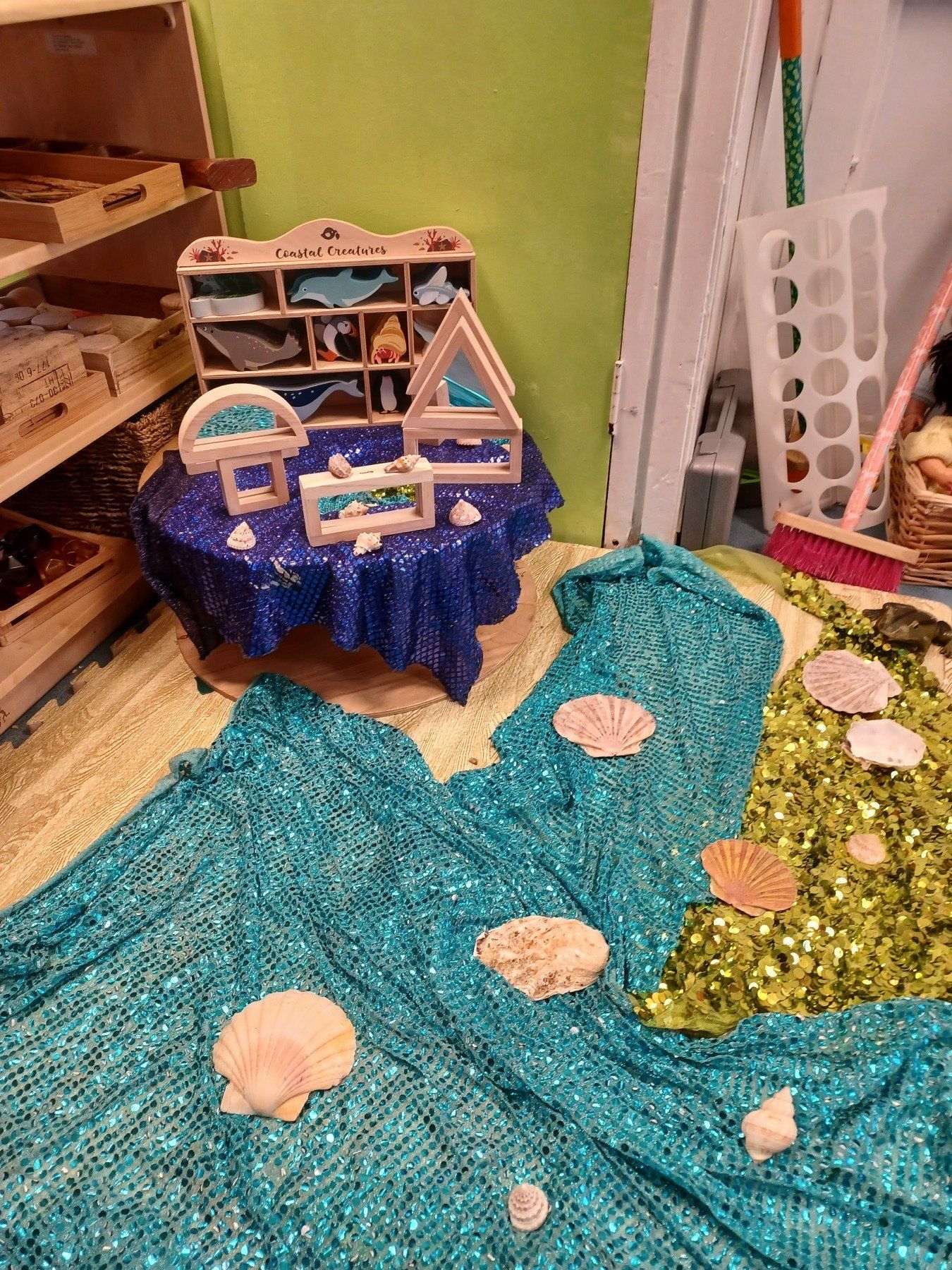 A room with a table and seashells on the floor.