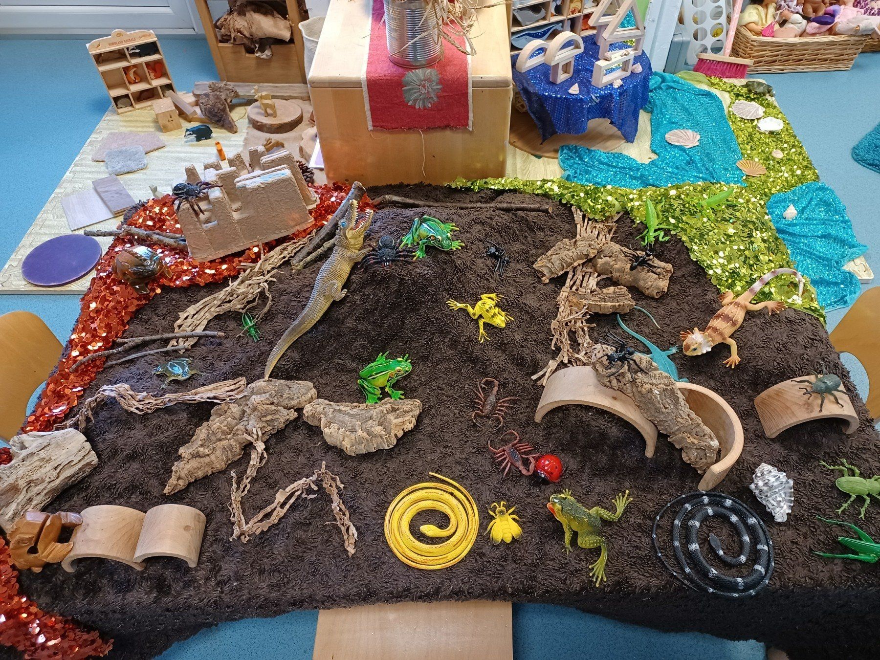 A table with a lot of toys on it and a skeleton of a dinosaur.