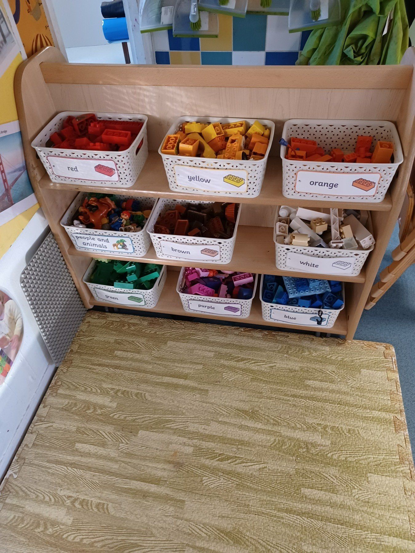 A shelf filled with baskets filled with different colored toys.